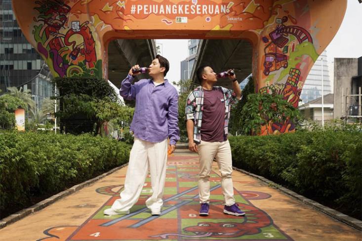 Ki-ka: Edric Tjandra (Influencer) dan Andes Gumilang Hadisucipto (Frontline Senior Brand Manager Coca-Cola Indonesia) di mural FANTA di kawasan Kuningan, Jakarta (26/09). Foto: Ist