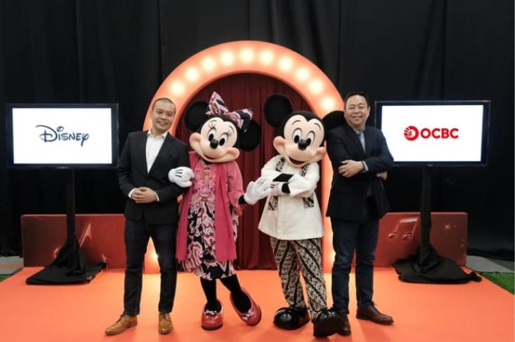 Ki-ka: Tan Wee (Director, Brand Commercialization, The Walt Disney Company Indonesia) dan Johannes Husin (Director OCBC) bersama karakter Minnie and Mickey. Foto: Ist