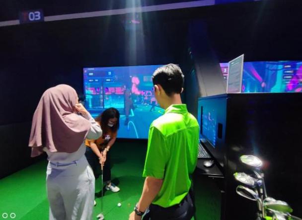Mencoba permainan indoor golf secara berkelompok