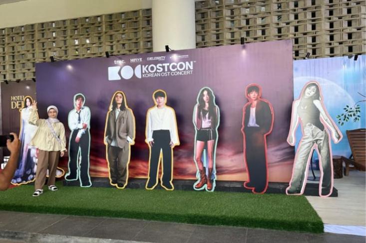 Seorang penggemar berfoto di depan poster ketujuh penyanyi. Foto: Novi
